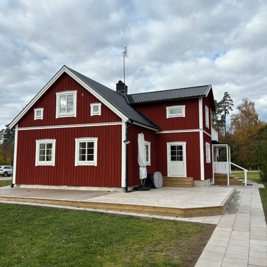 Fasadbyte och takbyte på rött hus med vita knutar.