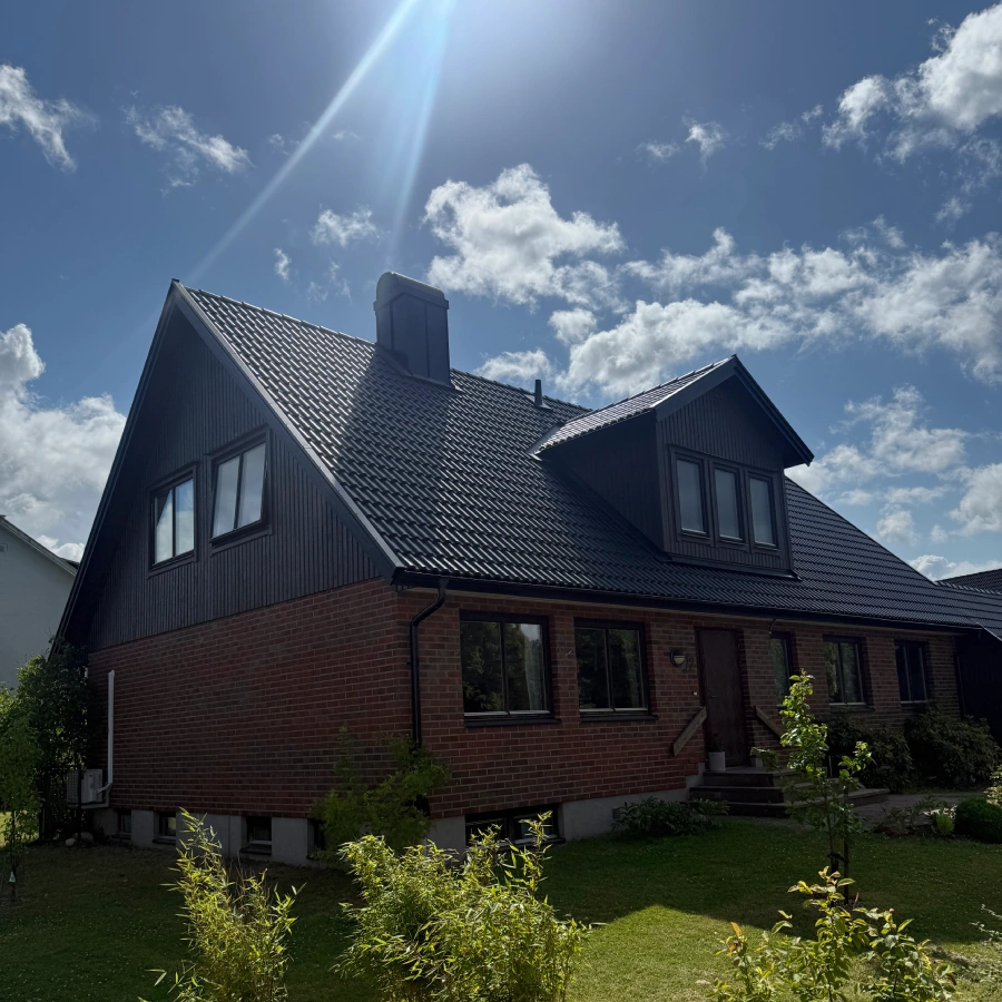 Brunt tegelhus efter ett takbyte och fasadrenovering