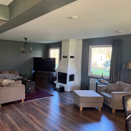 Nytt vardagsrum med braskamin efter invändig renovering i Markaryd